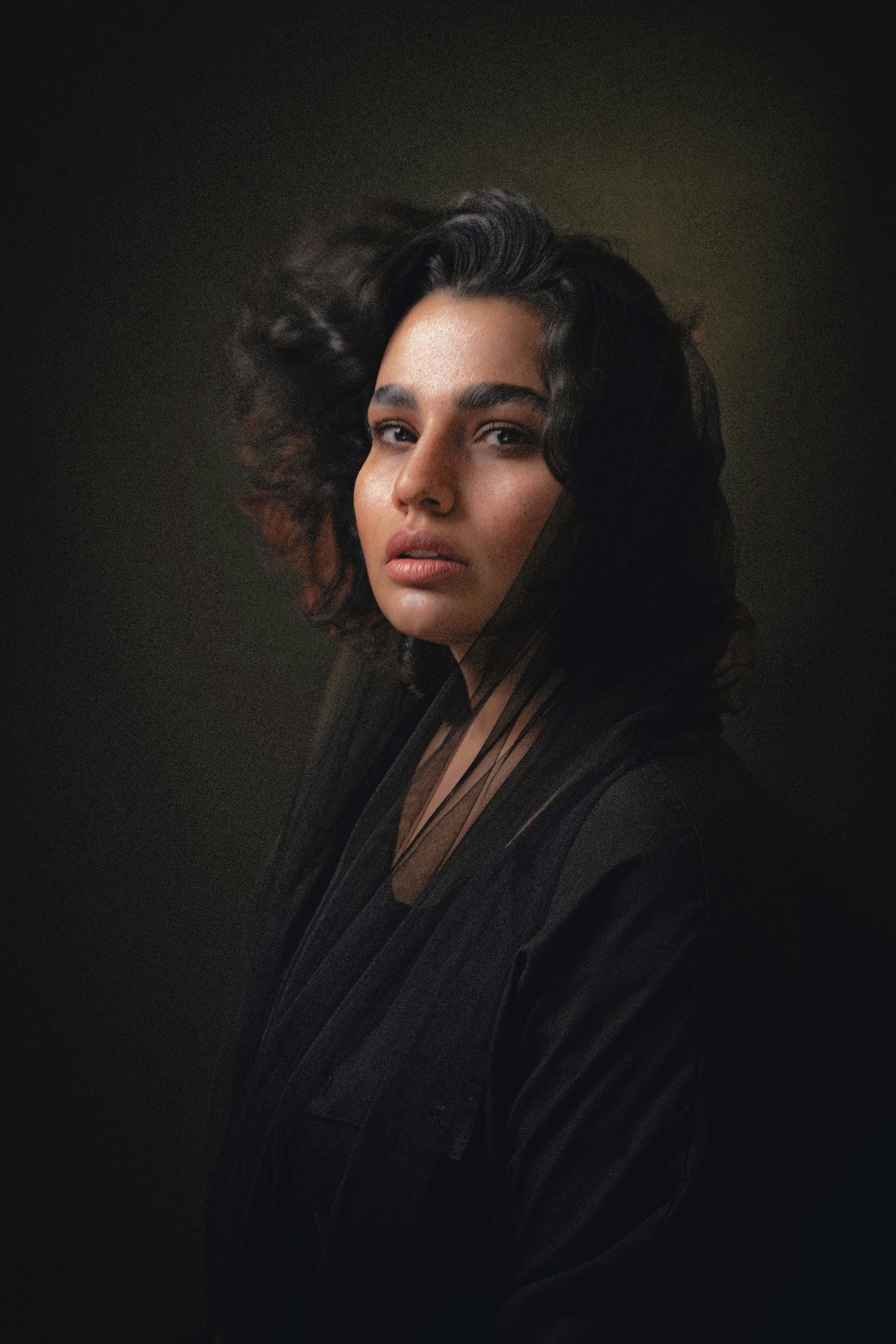 Sasha Verrill, photographed in a black wrap top against a dark backdrop